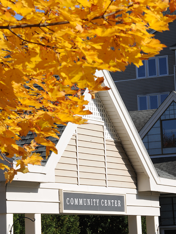 Kendal at Hanover Community Center entrance with yellow fall leaves overhead