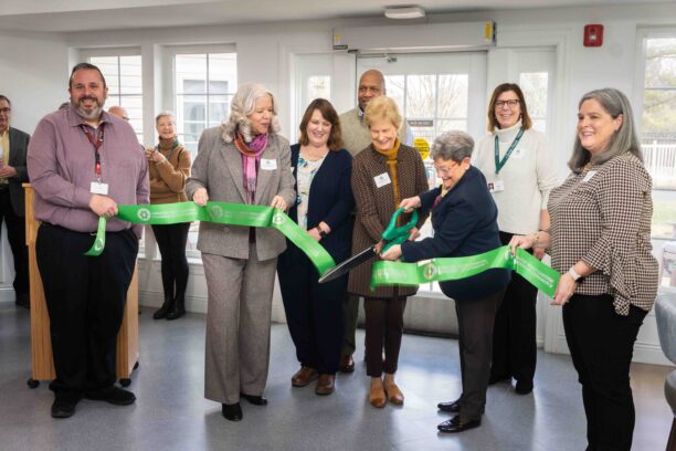 Seven people cutting ribbon
